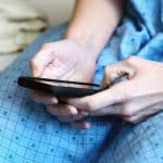 Paciente em tratamento de câncer mexendo em celular