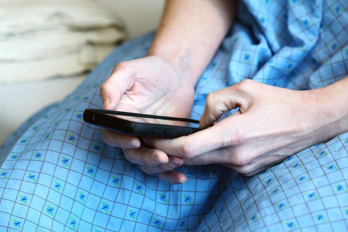 Paciente em tratamento de câncer mexendo em celular