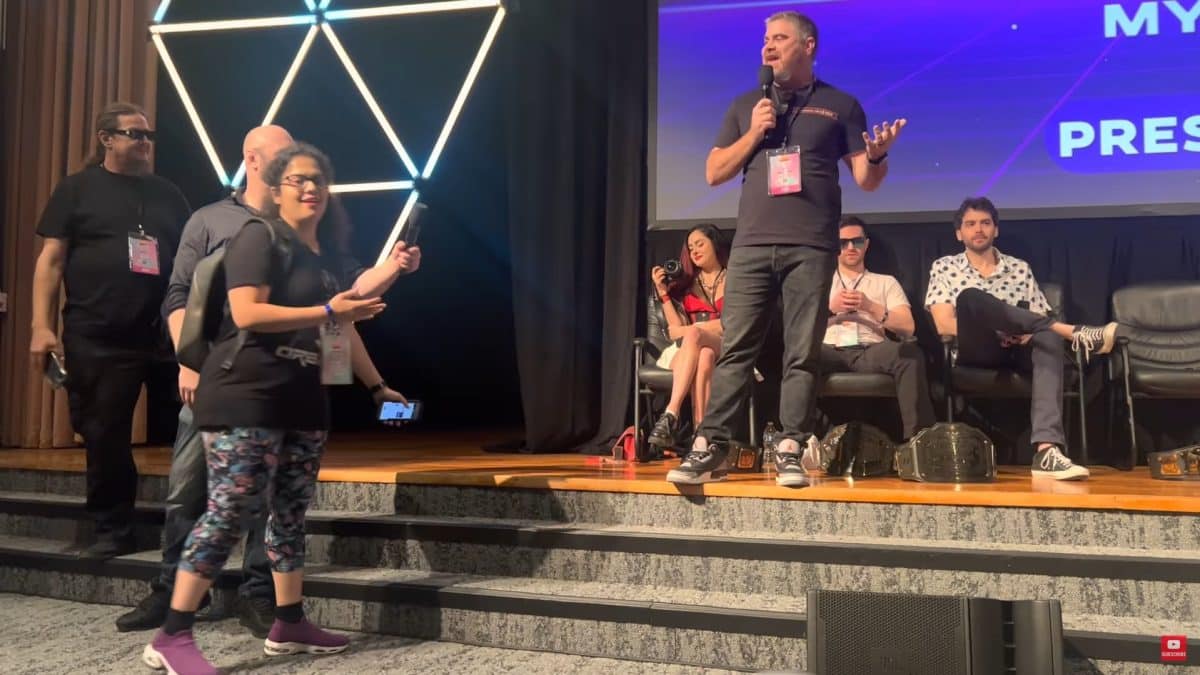Em evento presencial, mulher acusa youtuber de receber dinheiro para promover criptomoedas suspeitas a seus seguidores. Fonte: YouTube/Reprodução.