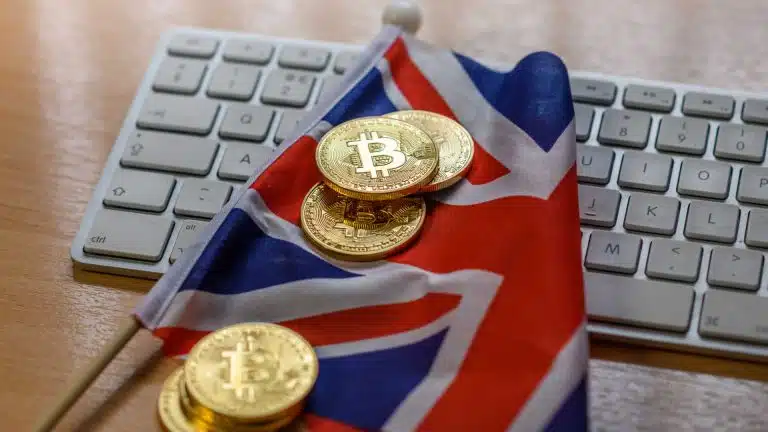 Bandeira do Reino Unido e moedas de Bitcoin.