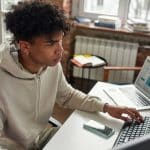 Jovem trabalhando em computador.