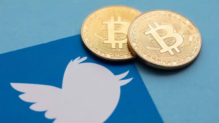Logo do Twitter e moedas de Bitcoin.