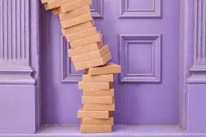 Caixas caindo em frente a porta roxa, caixinhas do Nubank