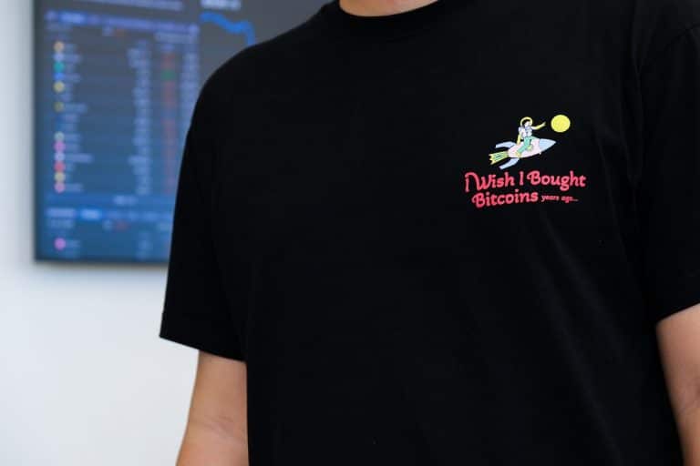 Homem com camisa de bitcoin com desejo de ter comprado no início