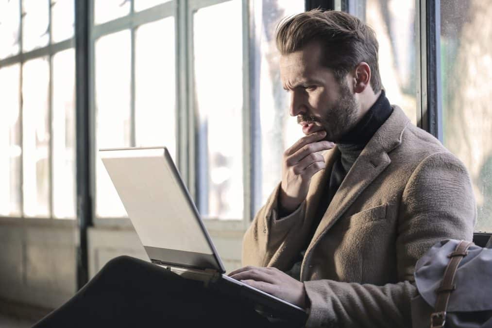 Homem olhando preocupado para tela de notebook