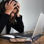 Mulher desesperada ao olhar para tela de computador