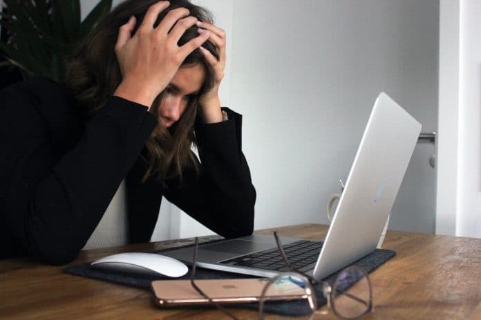 Mulher desesperada ao olhar para tela de computador