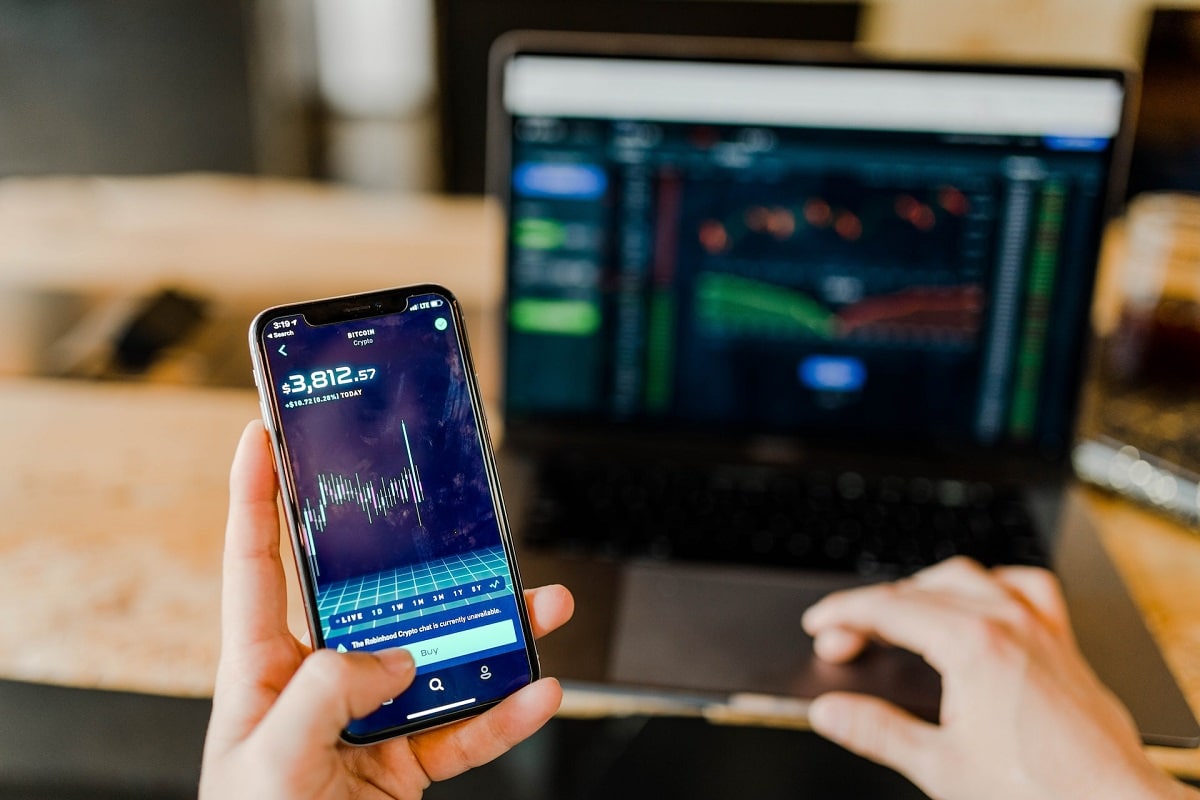 Trader de bitcoin em aplicativo e tela de notebook