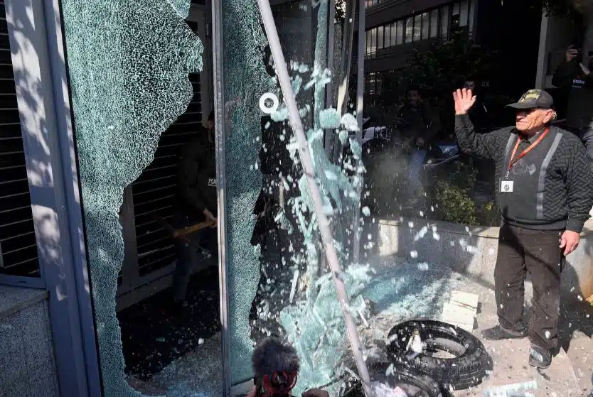 Um cliente do banco quebra o vidro da entrada do banco BBAC durante um protesto organizado pelo Depositors' Outcry, no bairro de Badaro em Beirute, Líbano. EPA