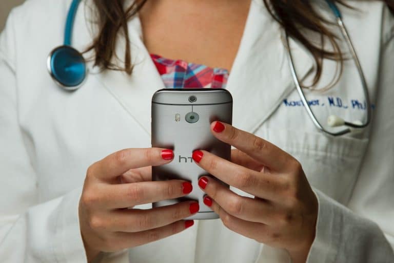 Profissional médica segurando aparelho celular