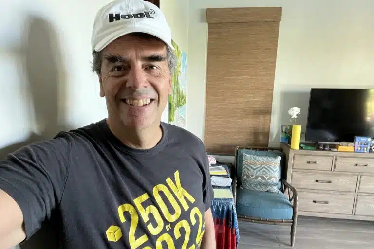 Bilionário Tim Draper com camiseta e boné fazendo referências ao bitcoin
