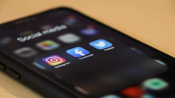 Celular com redes sociais Instagram, Facebook e Twitter em destaque