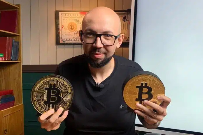 Daniel Constantino, contador e sócio do Grupo Primo, segurando Bitcoins simbólicos criptomoedas declaração