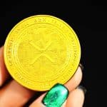 Mão segurando criptomoeda simbólica da XRP