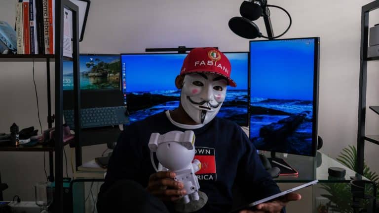 Mascarado segurando robô e tablet Boitumelo Phetla