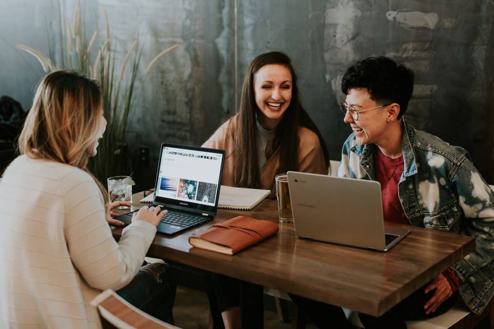 Mulheres rindo ao trabalhar no computador