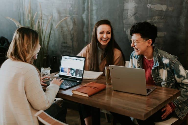 Mulheres rindo ao trabalhar no computador