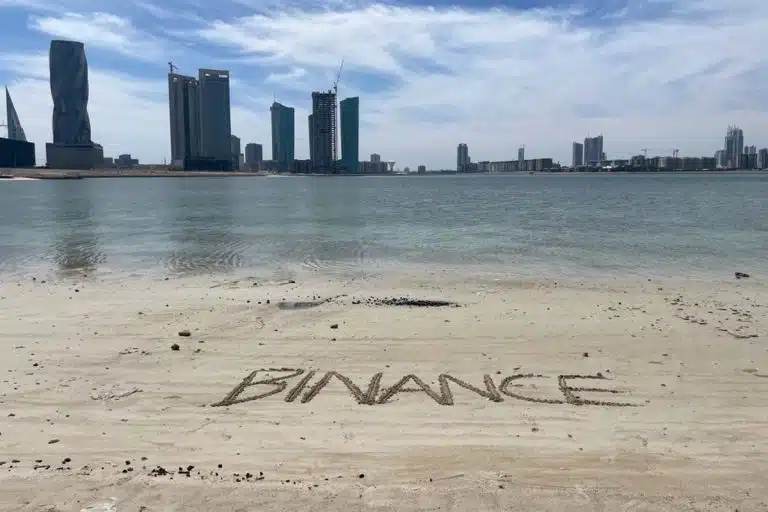 Nome Binance escrito na areia da praia