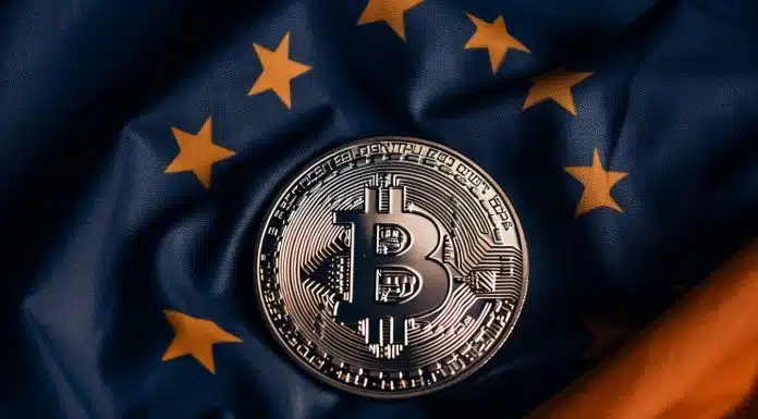 Bandeira da União Europeia e moeda de Bitcoin.