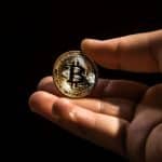 Mão segurando moeda de Bitcoin. Midjourney.