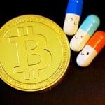 Símbolo do bitcoin próximo de pílula laranja com rosto feliz