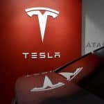 veículo estacionado próximo a placa da Tesla