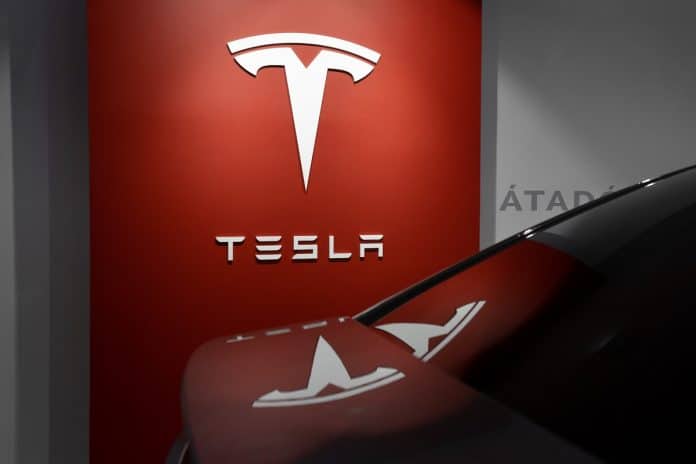 veículo estacionado próximo a placa da Tesla