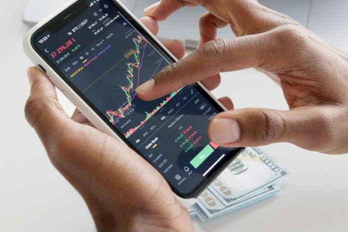 Homem mexendo em tela de celular de negociação de bitcoin em USDT
