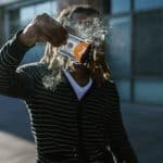 Homem segurando nota pegando fogo com símbolo do bitcoin