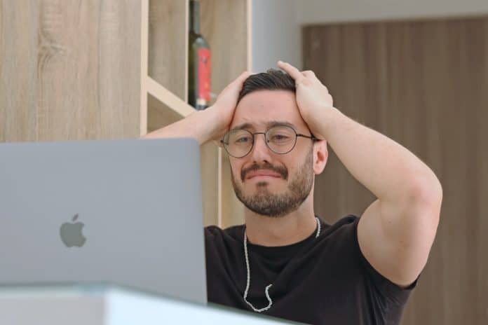 Homem triste ao olhar para tela de computador