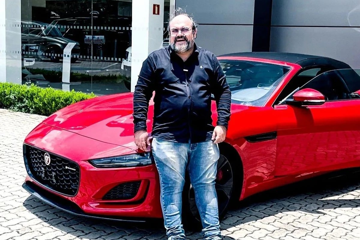 Vovô Rico ao lado de carro vermelho