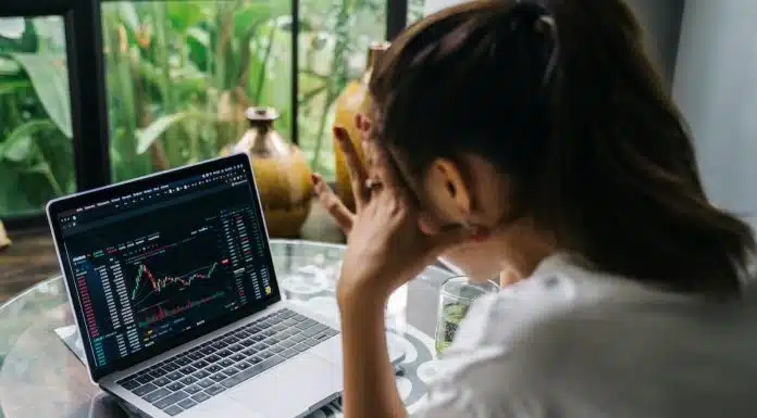 Mulher olhando para tela de negociação de criptomoedas de corretora