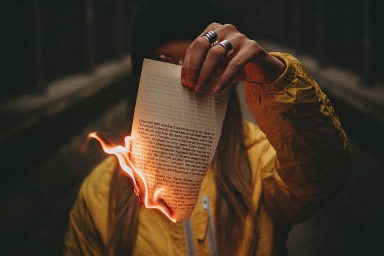 Mulher segurando papel queimando