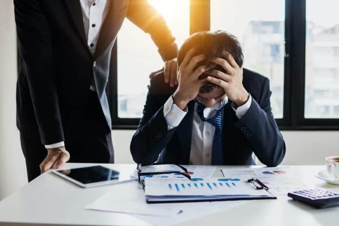 Homem consolado após prejuízos