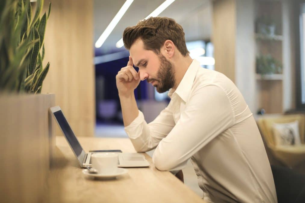 Homem preocupado ao olhar para tela de computador