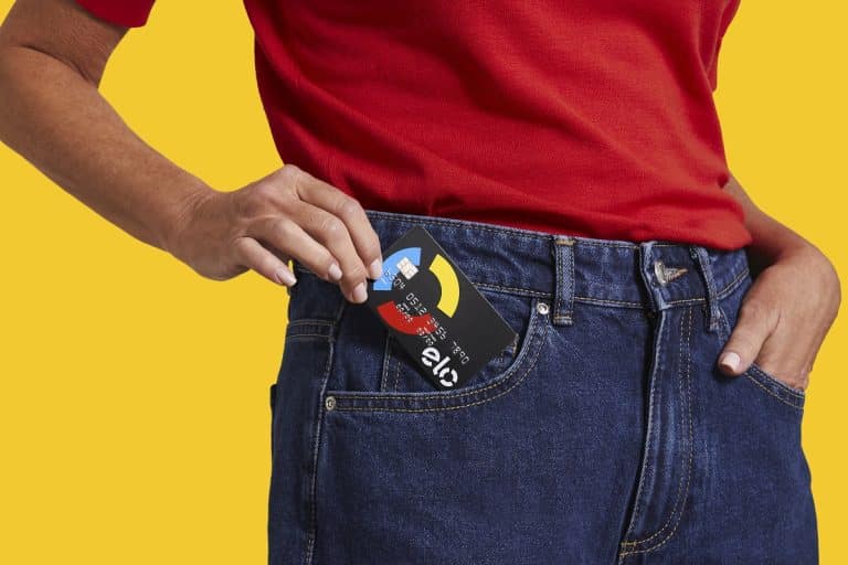 Mulher com cartão Elo no bolso