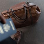 Homem com passaporte na mão e sapato sem meia