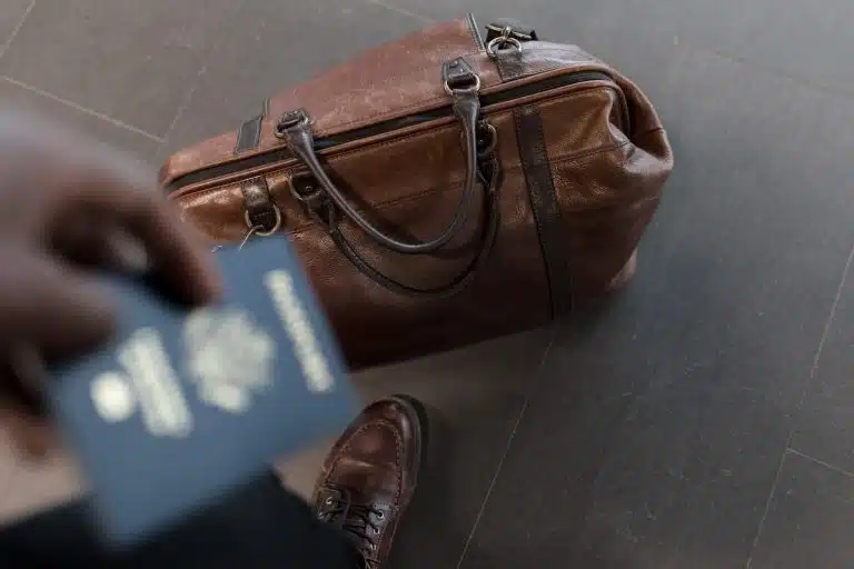 Homem com passaporte na mão e sapato sem meia
