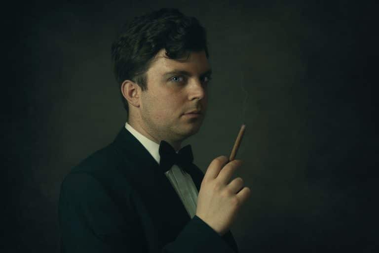 Homem segurando charuto com roupa elegante