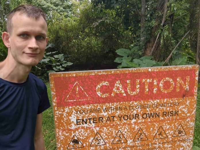 Vitalik Buterin, criador do Ethereum, ao lado de placa de perigo. Fonte: Redes sociais/Reprodução.