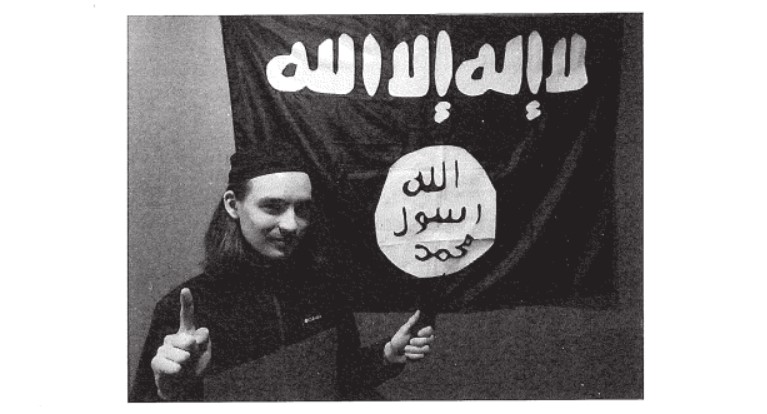 Alexander Scott Mercurio, preso pelo FBI, em frente à bandeira do Estado Islâmico. Fonte: DoJ/Reprodução.