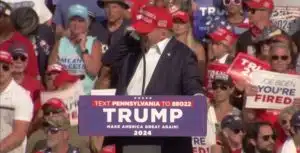 Momento em que Donald Trump é baleado e leva mão à orelha. Fonte: YouTube/Reprodução.