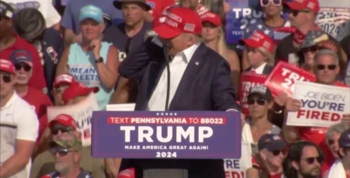 Momento em que Donald Trump é baleado e leva mão à orelha. Fonte: YouTube/Reprodução.