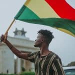 Homem segurando bandeira de Gana bitcoin criptomoedas regulação
