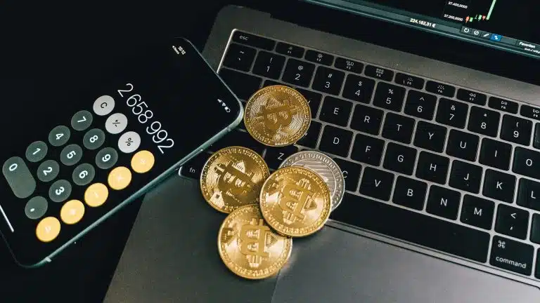 Celular e bitcoins sobre um notebook ferramentas análises