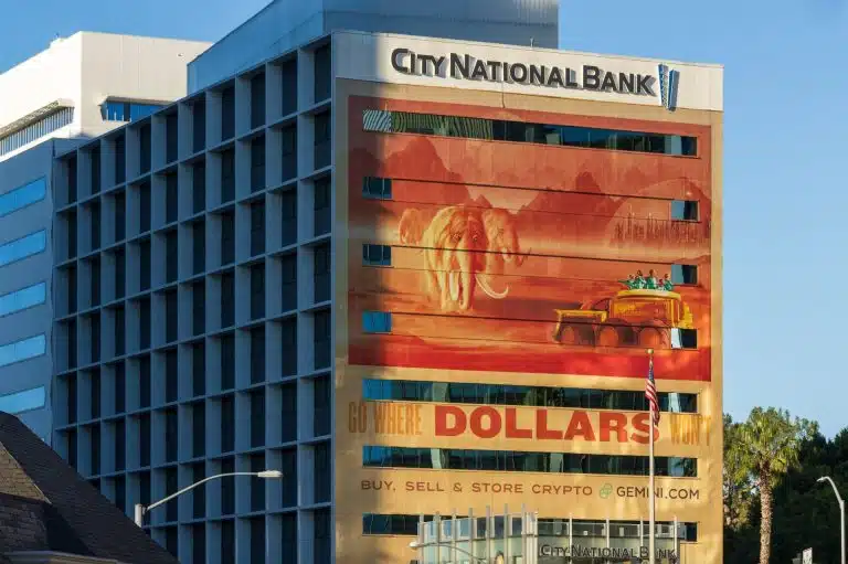 Fachada do City National Bank coberto com publicidade de corretora de bitcoin