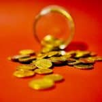 Moedas caindo de pote com fundo vermelho