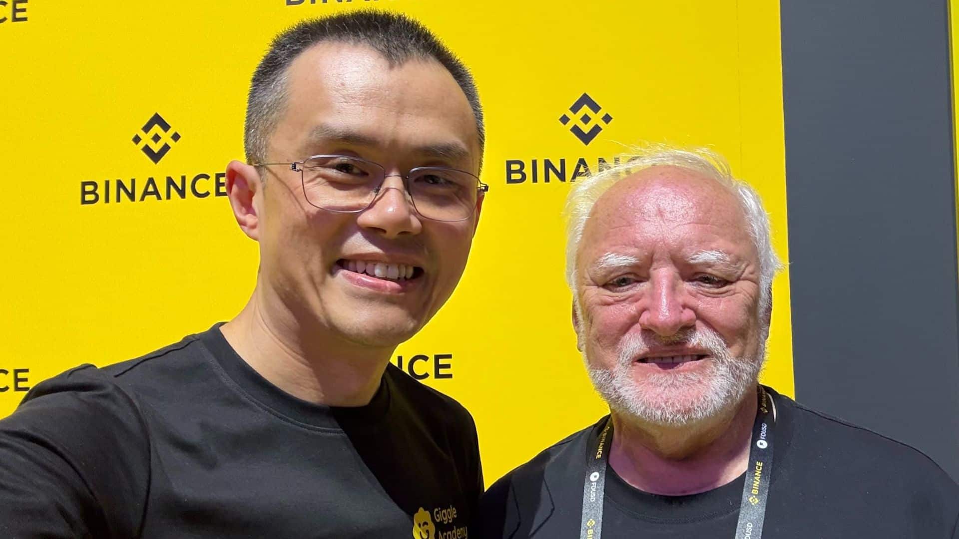 CEO da Binance, CZ, ao lado de homem ligado a memes