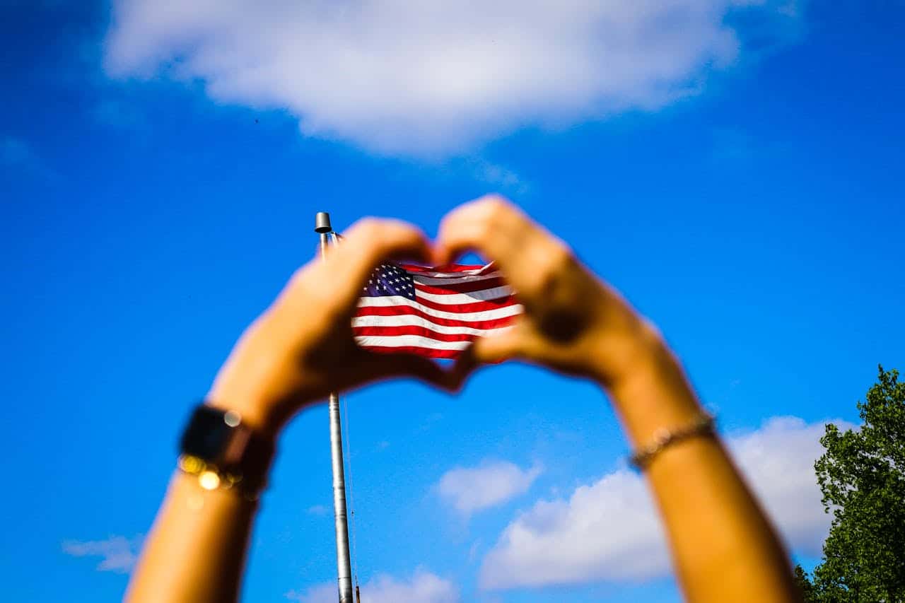 Mão fazendo símbolo de coração para a bandeira dos EUA