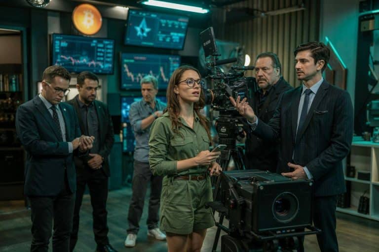 Equipe de filmagens de cinema próximos de gráficos de criptomoedas e símbolo do bitcoin